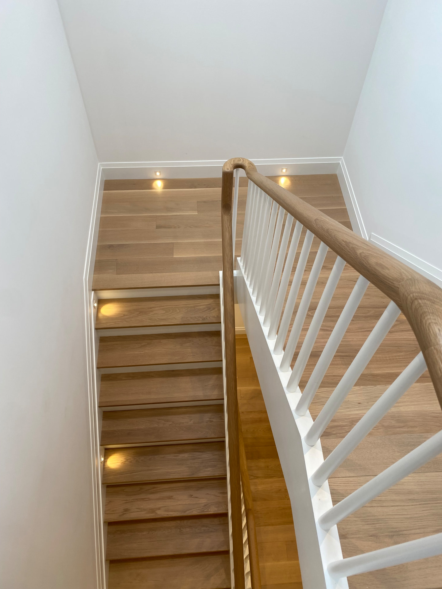 Escalera de madera con barandal blanco instalada por DTH